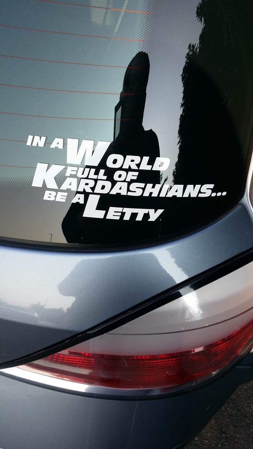 Weißer Letty Aufkleber mit dem Spruch „In a World full of Kardashians… be a Letty“ auf der Heckscheibe eines grauen Autos