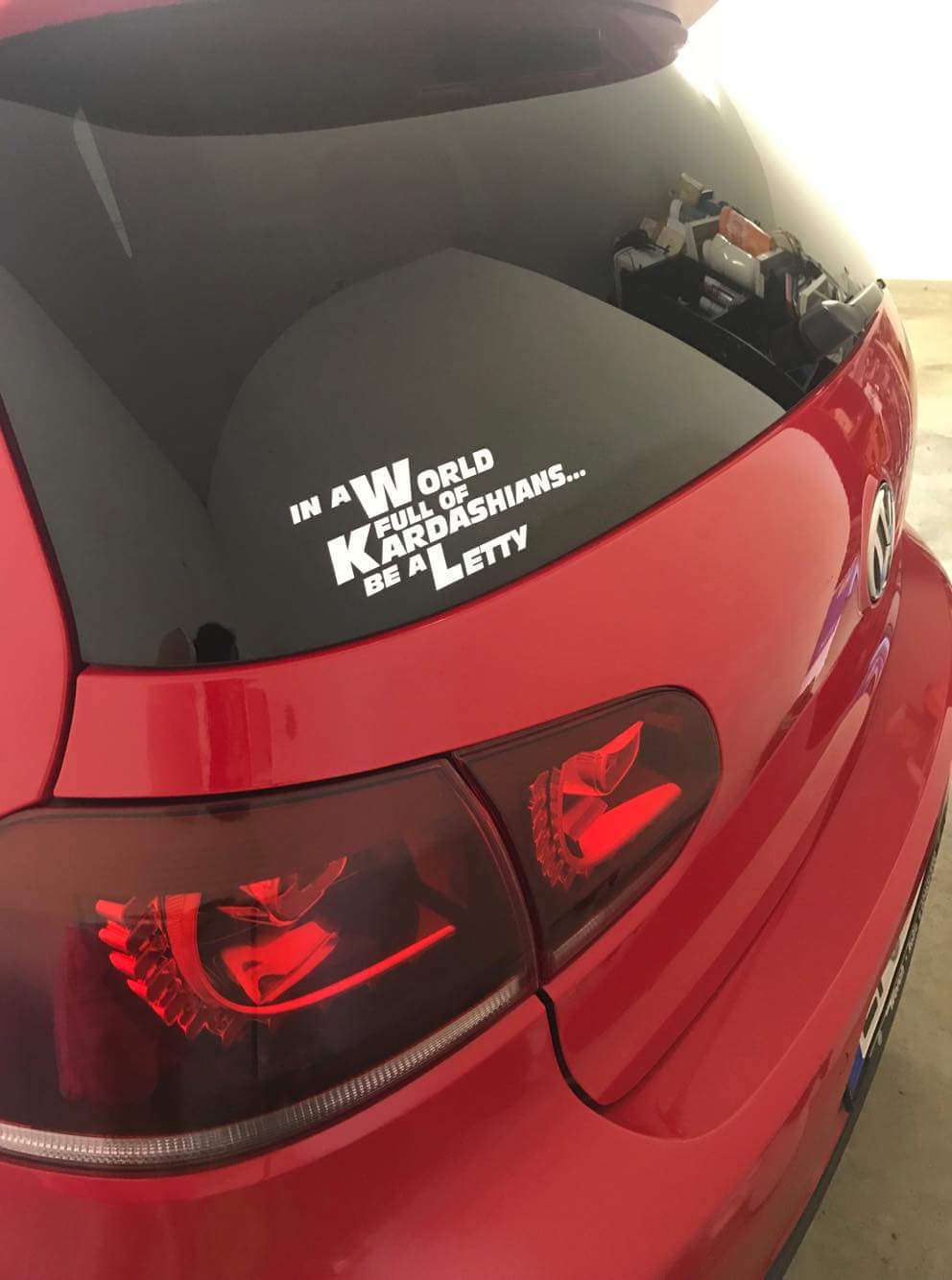 Weißer Letty Aufkleber mit dem Spruch „In a World full of Kardashians… be a Letty“ auf der Heckscheibe eines roten Autos