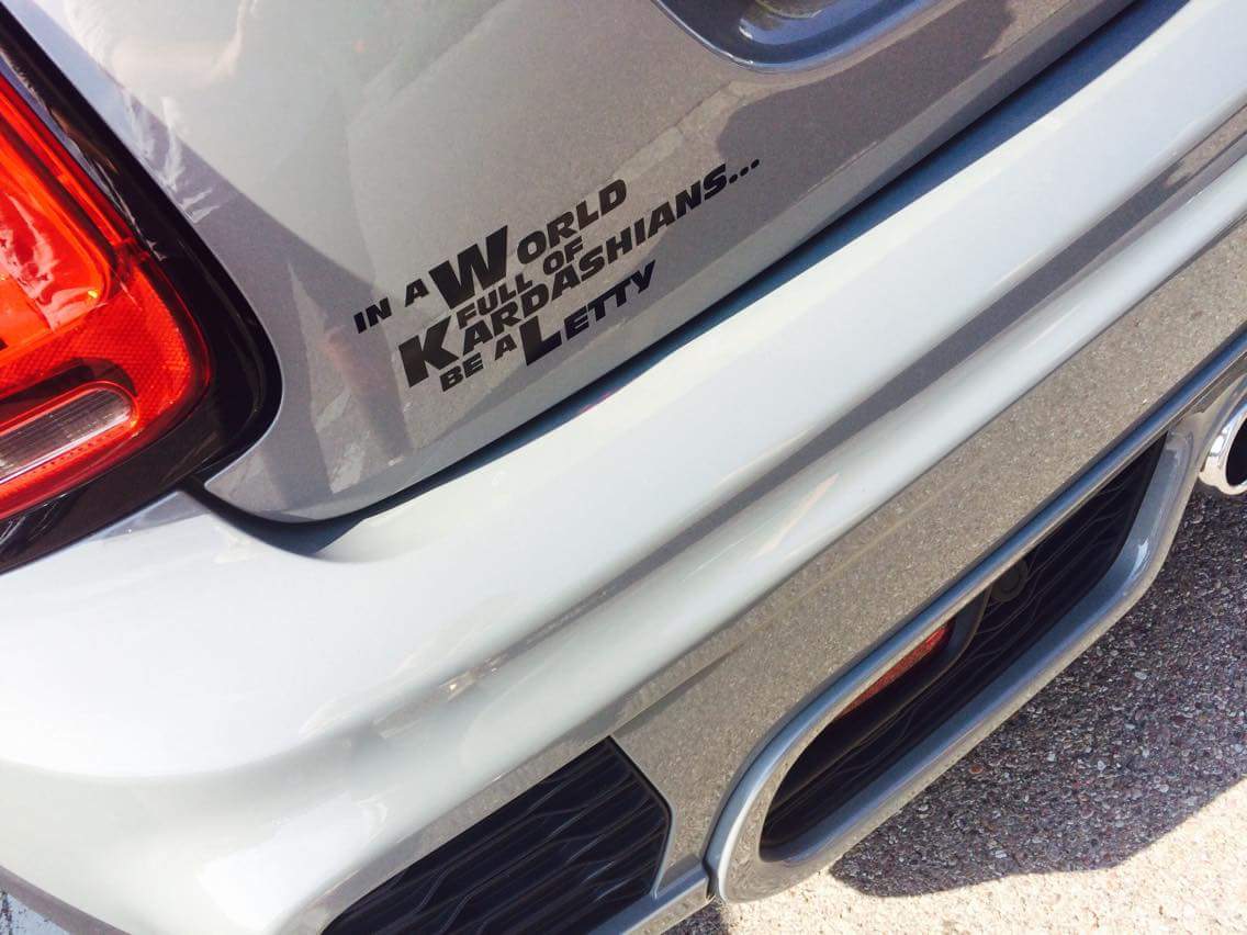 Schwarzer Letty Aufkleber mit dem Spruch „In a World full of Kardashians… be a Letty“ am Heck eines weißen Autos