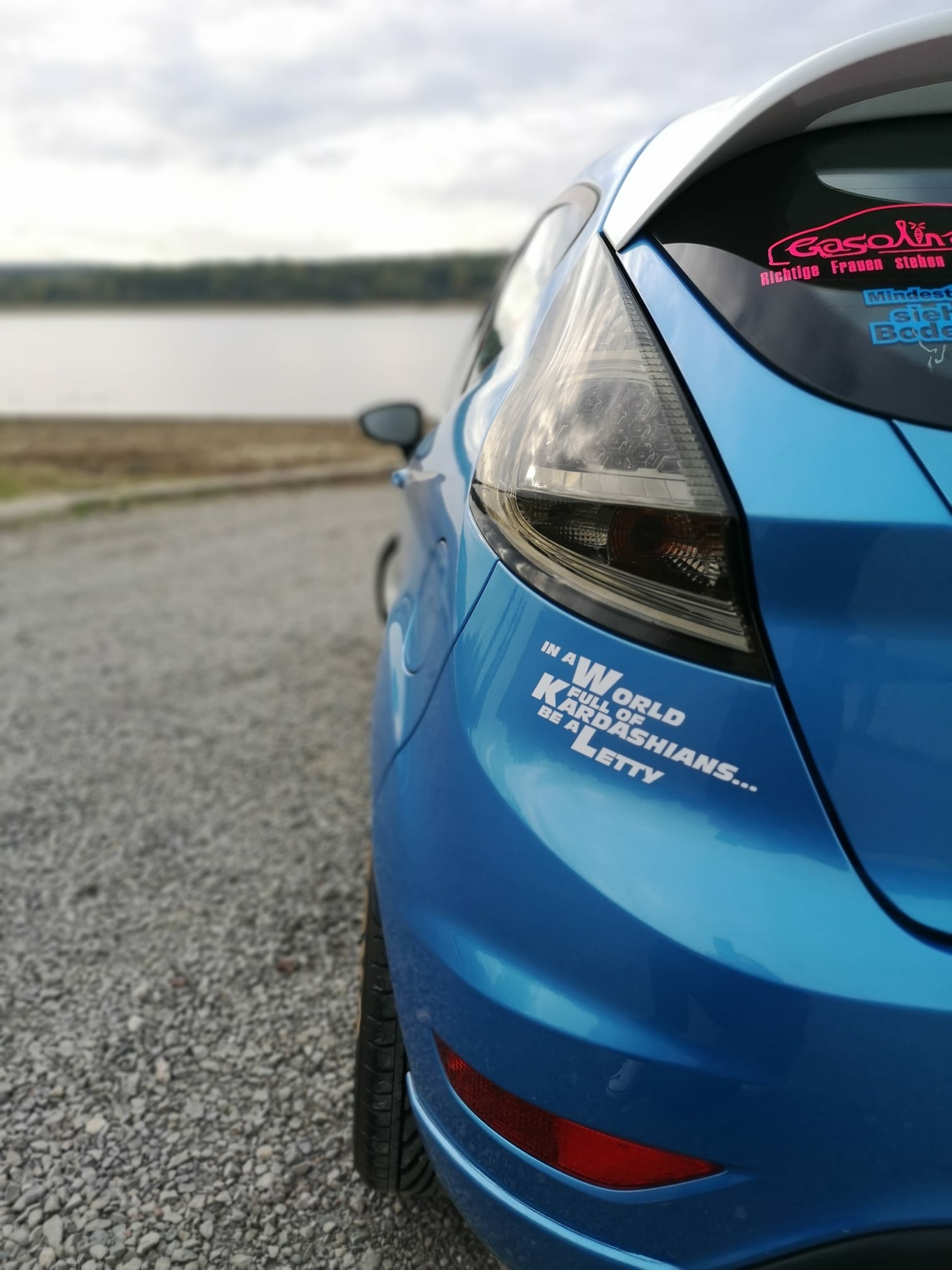 Weißer Letty Aufkleber mit dem Spruch „In a World full of Kardashians… be a Letty“ am Heck eines blauen Autos